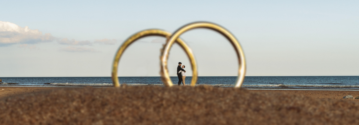 gay couple framed in wedding rings